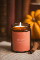 pumpkin scented candle in an amber jar with orange label 