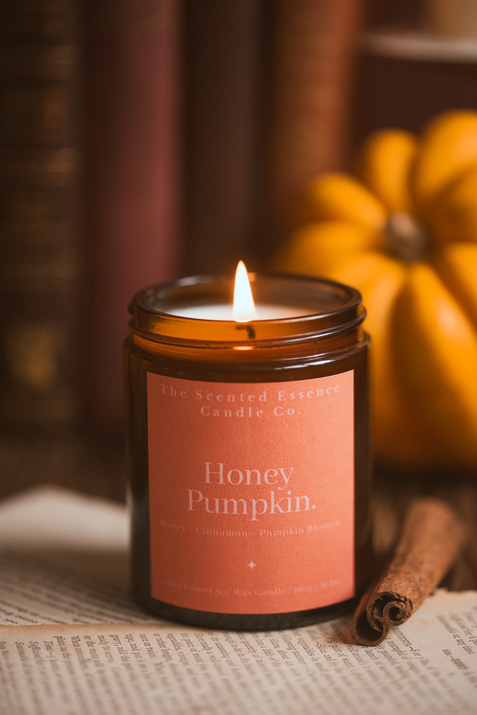 pumpkin scented candle in an amber jar with orange label 